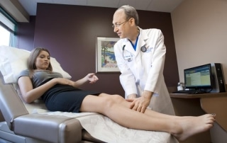 examining patients legs for spider or varicose veins in Plano TX
