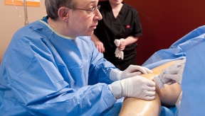 nurse assisting Dr. Klein during a varicose vein procedure in Plano TX